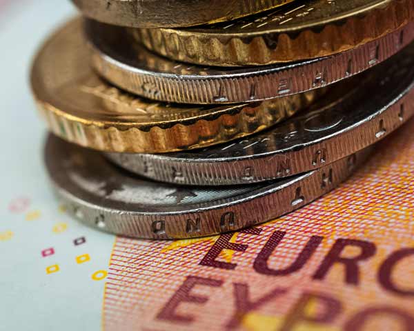 Geldschein und Euro-Münzen symbolisieren den Mindestlohn